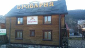 um edifício de madeira com uma placa em cima em Cottage u Yaremy Mykulychyn em Mykulychyn