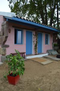 een roze en blauw huis met een potplant ervoor bij La Coquille Napoléon in Saint-Jean-Pied-de-Port +6 foto's