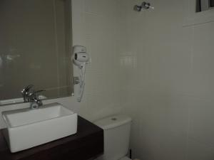 baño con lavabo y teléfono en la pared en Canela - 2 suítes - Vivendas do Lago, en Canela