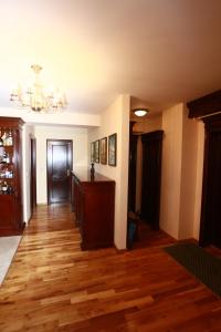 a living room with wooden floors and a chandelier at Penthouse Renașterii Amazonia in Timişoara