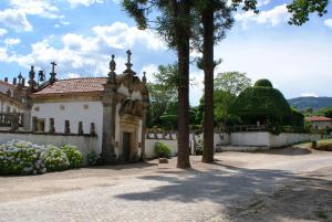 a white building with trees and a fence at Casa do Campo - Turismo de Habitação in Celorico de Basto
