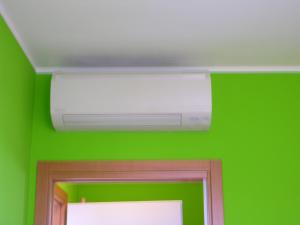 a ceiling with a light and a green wall at Appartamenti Foyer in Bibione +4 photos