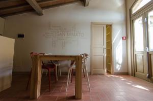 サン・ミニアートにあるOstello San Miniatoの壁に看板が付いた部屋内のテーブルと椅子