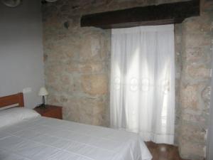sypialnia z białym łóżkiem i oknem w obiekcie Apartamentos Puente Viesgo Anjana w mieście Puente Viesgo