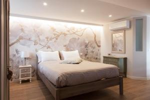 a bedroom with a bed with a floral wall at La Pulcia B&B in Gradara