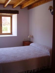 1 dormitorio con cama y ventana en Apartamentos Puente Viesgo Anjana en Puente Viesgo