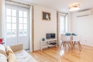 uma sala de estar com um sofá branco e uma mesa em Sendme2Portugal: Loureiro no Porto