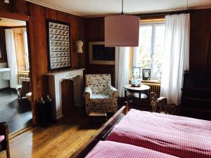 a bedroom with a bed and a chair and a fireplace at Auberge de l'Assesseur - Mont-Soleil in Saint-Imier