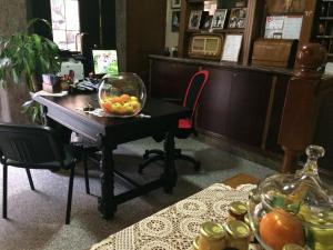 biuro z biurkiem i miską owoców w obiekcie Albergo Stella w mieście Tolè