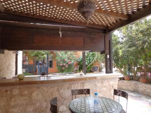 a table and chairs under a wooden pergola at Villa Grenadine in Essaouira
