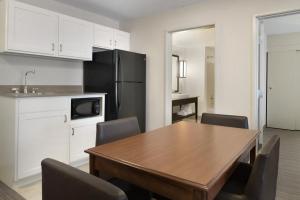 a kitchen with a table and chairs and a refrigerator at Country Inn & Suites by Radisson, Houghton, MI in Houghton