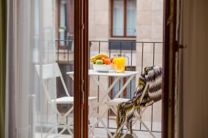 a table with a bowl of fruit and drinks on a balcony at Colours Apartments Budapest in Budapest