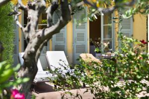 - une terrasse couverte avec une chaise et une table fleurie dans l'établissement Hotel Royal-Riviera, à Saint-Jean-Cap-Ferrat