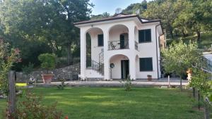 une maison blanche avec une terrasse couverte et une cour dans l'établissement Incanto di Luna, à Ispani