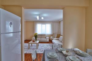 Afyon Can Termal Apart في افيون: مطبخ وغرفة معيشة مع طاولة وثلاجة