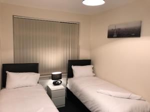 two beds sitting next to each other in a room at Victoria Parade Apartment in Hull