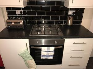 uma cozinha com um fogão e uma torradeira. em Victoria Parade Apartment em Hull