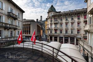 einen Balkon mit Stadtblick und Gebäuden in der Unterkunft Hotel Croce Federale in Bellinzona