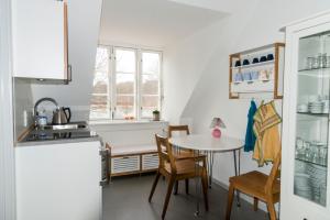 a small kitchen with a small table and chairs at PilgrimsHuset Maribo in Maribo