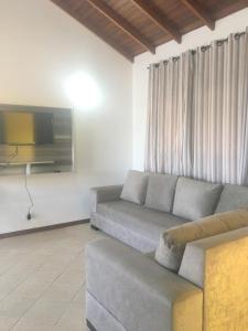 een woonkamer met een bank en een tv bij Apartamento em Residencial Riviera in Florianópolis