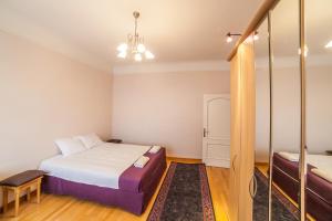 Heart of Old-Town Apartments في ريغا: غرفة نوم صغيرة مع سرير ومرآة