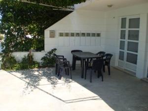Un patio con una mesa y sillas frente a un edificio. en Apartments Z, en Dugi Rat