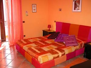 a bedroom with a colorful bed with pillows on it at B&B Alla Fiera in Ponte Galeria
