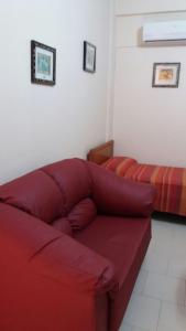 uma sala de estar com um sofá vermelho e uma cama em Agathae Hotel & Residence em Scoglitti