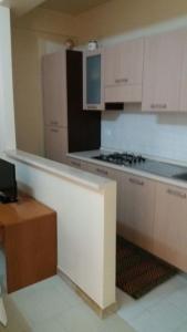 uma cozinha com armários brancos e um forno com placa de fogão em Agathae Hotel & Residence em Scoglitti