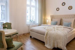 a bedroom with a bed and a table and window at Leon Apartments in Leipzig
