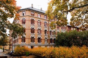 a large red brick building with trees in front of it at Nordic Host - Deichmans Gate 10 in Oslo