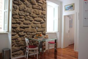 City Break Dubrovnik Apartments في دوبروفنيك: طاولة في غرفة مع جدار حجري +23 صورة