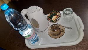 a bottle of water sitting on a tray with a sink at Siyaniye Hotel in Syktyvkar