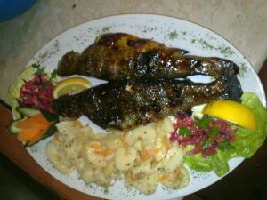 a plate of food with meat and vegetables on it at Lisine smeštaj Vodopad in Strmosten