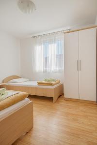a bedroom with two beds and a large white cabinet at Apartments Mia in Baška
