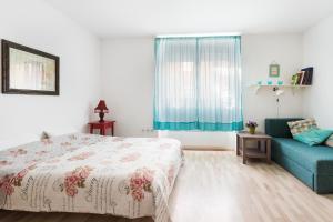 sypialnia z łóżkiem i niebieską kanapą w obiekcie Apartment Roza w Zagrzebiu