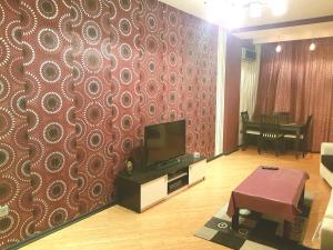 una sala de estar con TV y una pared con un patrón en Apartment on MirQasimov st.29, en Baku