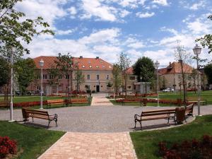 two benches in a park with a building in the background at Apartment Gorska vila in Ogulin