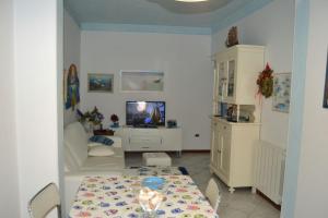 un soggiorno con tavolo e TV di Appartamento Manola a Viareggio