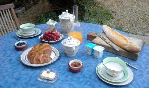 a blue table with a breakfast of croissants and fruit at Villa Fontilha in Usclas-lʼHérault