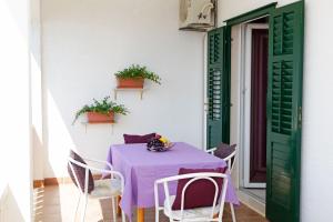 un tavolo con una tovaglia viola e sedie in una stanza di Katica apartments a Bol