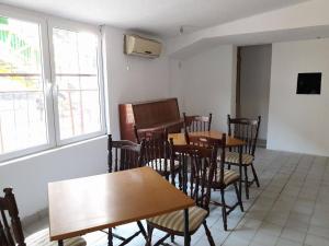 a dining room with tables and chairs and a piano at Vila Dule in Ohrid