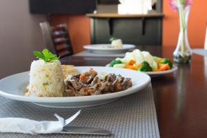 un plato de comida con arroz y verduras en una mesa en Porto Hotel, en Lázaro Cárdenas