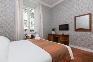 sypialnia z łóżkiem, biurkiem i lustrem w obiekcie Suite Beccaria A Piazza Del Popolo w Rzymie