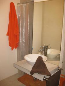 La salle de bains est pourvue d'un lavabo blanc et d'un miroir. dans l'établissement La Casa del Rio, à Valle de Bravo