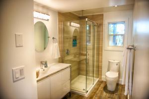 a bathroom with a shower and a sink and a toilet at The Francis Boutique Inn in Ucluelet