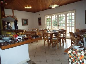 a dining room with wooden tables and chairs at Pousada In Garden in Teresópolis