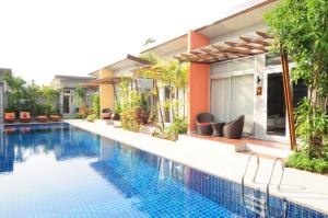 a swimming pool in front of a house at Phu NaNa Boutique Hotel - SHA Plus in Rawai Beach