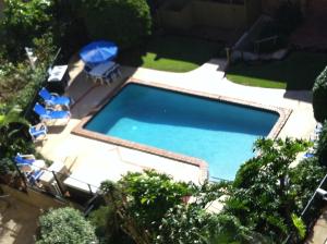 an overhead view of a swimming pool with chairs and umbrellas at Carool Holiday Apartments in Gold Coast