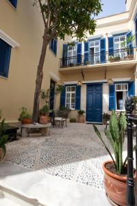 a courtyard of a building with blue doors and a tree at Suites Pandora in Chania Town